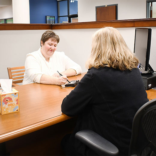 Expree staff member speaking with a member at her desk