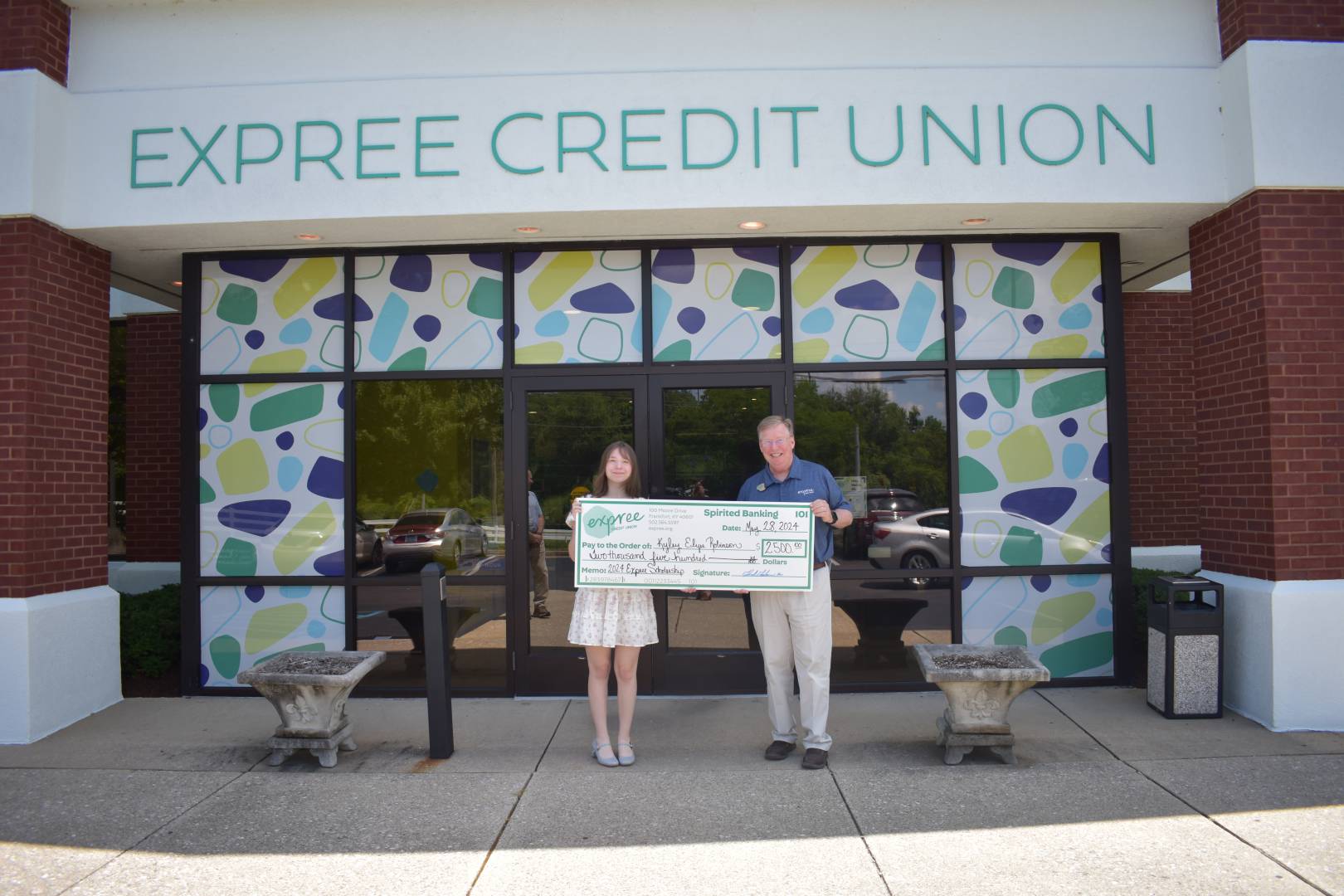 2024 scholarship recipient holds large check during presentation