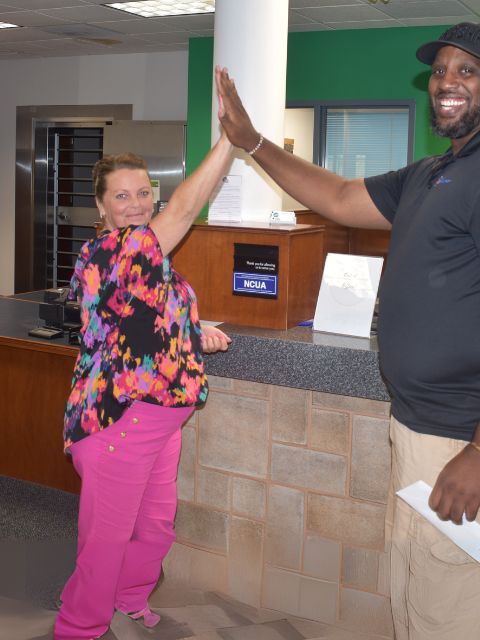 Expree Credit Union staff high fives a member.