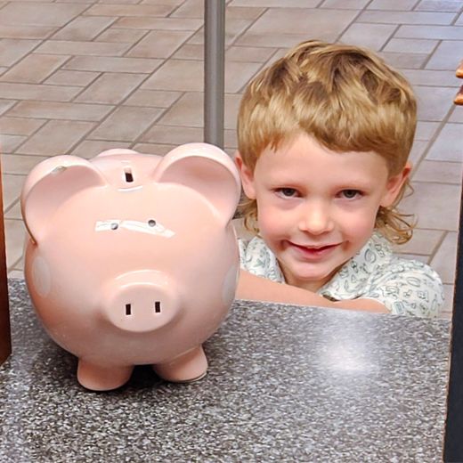 Person putting money in a piggy bank